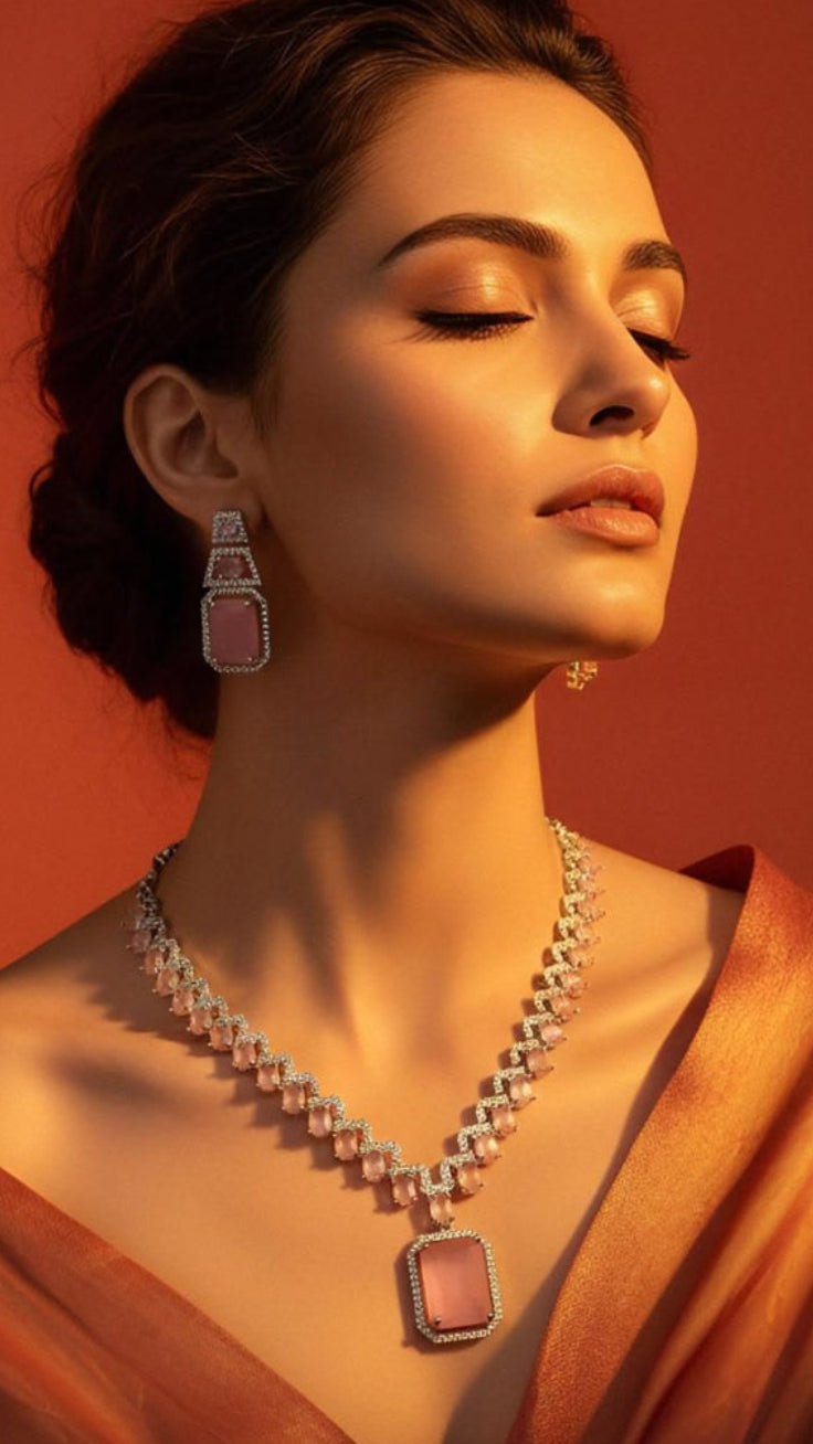 Woman wearing a necklace and earrings against an orange background